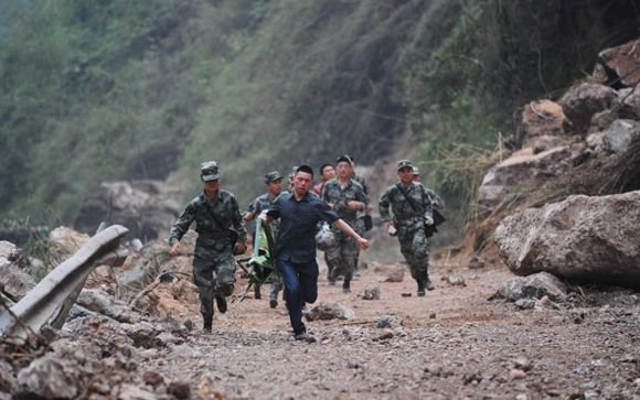 Rescue soldiers rush past a hazardous, quake-triggered landslide site to help victims in Lushan county - Image courtesy and copyright Xinhua